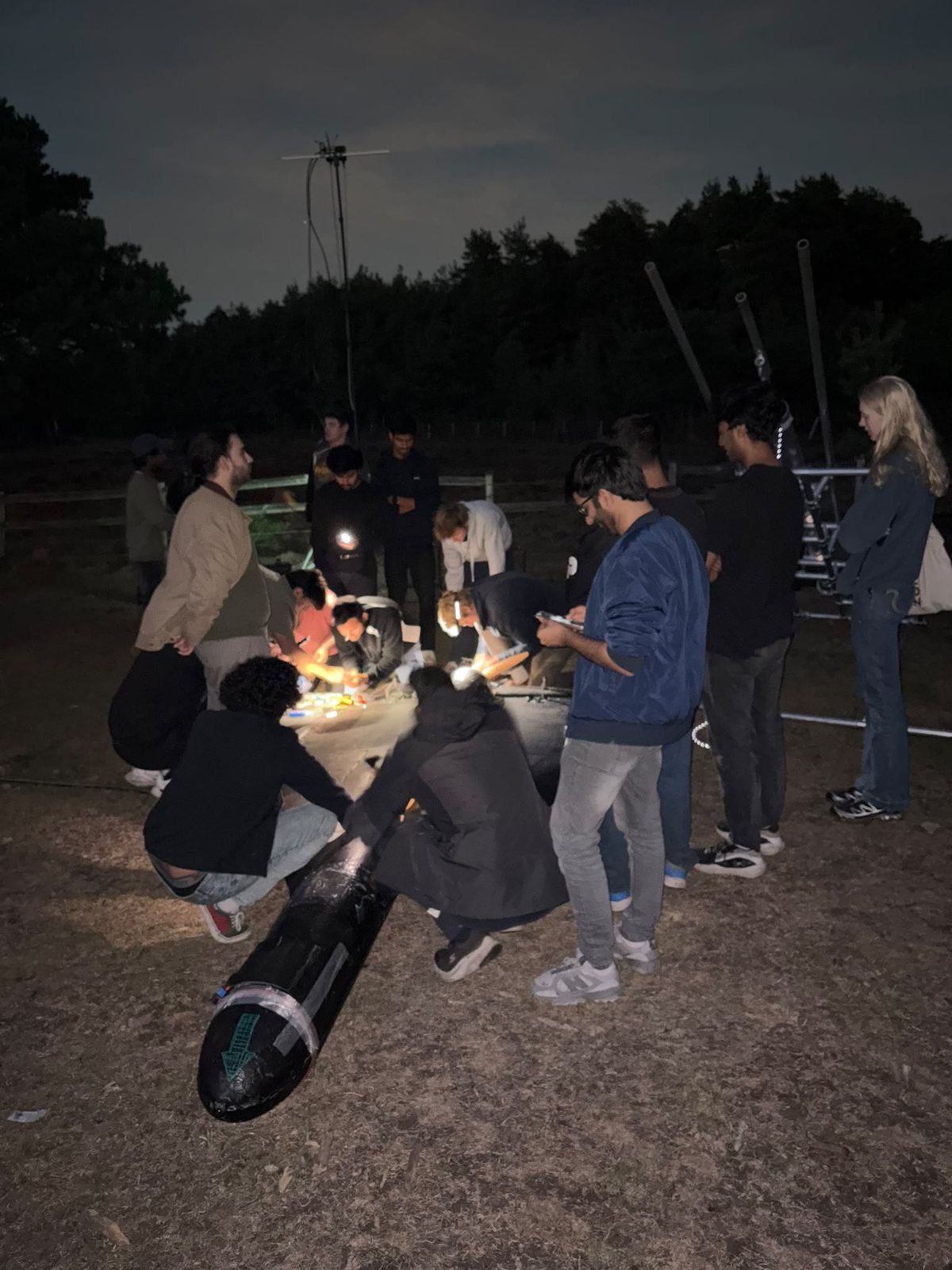 Engineers working on an airframe by torchlight after a trial